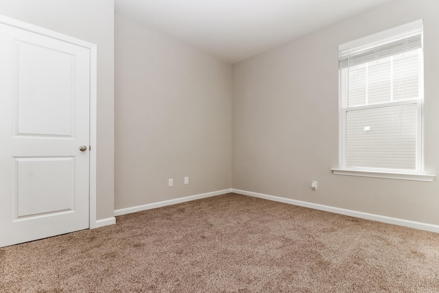 empty room with baseboards and carpet flooring