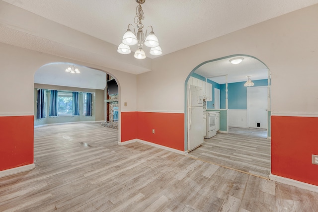 4606 Moss Ct, North Charleston, SC 29420 - spare room featuring a chandelier, wainscoting, light wood-style floors, arched walkways, and baseboards