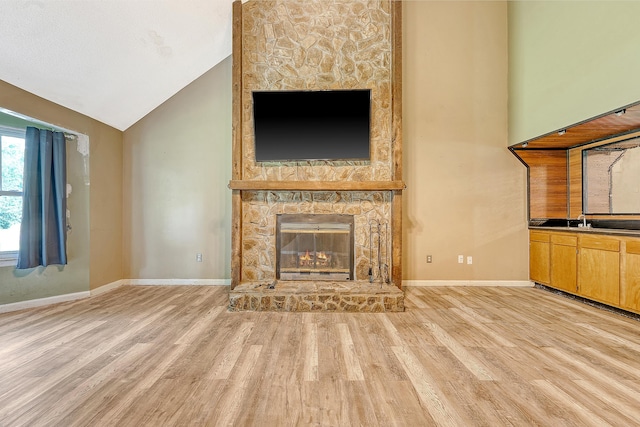 4606 Moss Ct, North Charleston, SC 29420 - unfurnished living room featuring light wood-style flooring, a stone fireplace, baseboards, and vaulted ceiling