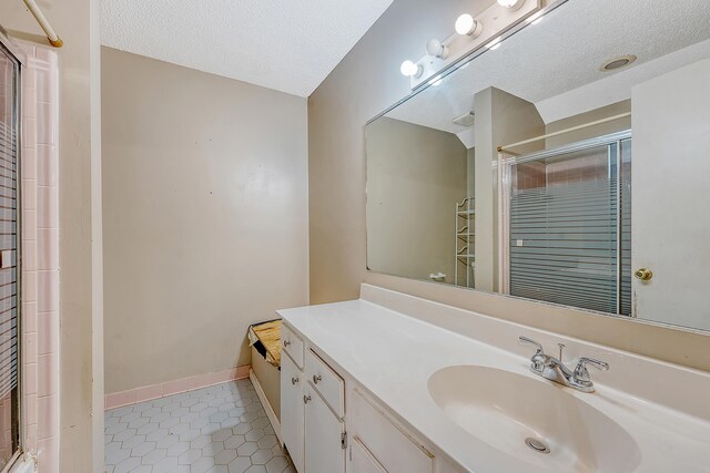 4606 Moss Ct, North Charleston, SC 29420 - full bath featuring a stall shower, a textured ceiling, vanity, tile patterned floors, and baseboards