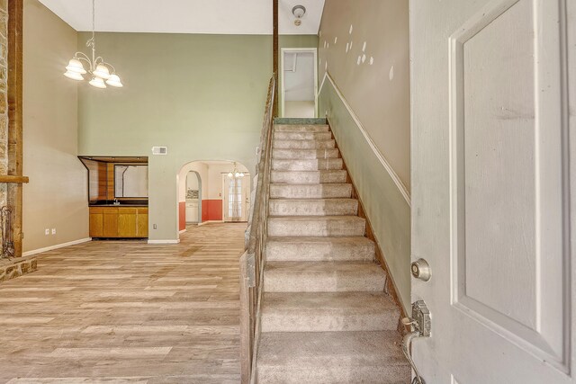 4606 Moss Ct, North Charleston, SC 29420 - stairs with arched walkways, wood finished floors, a chandelier, high vaulted ceiling, and baseboards