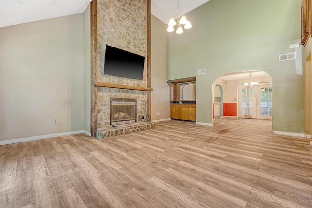 4606 Moss Ct, North Charleston, SC 29420 - unfurnished living room with arched walkways, a chandelier, high vaulted ceiling, a fireplace, and wood finished floors