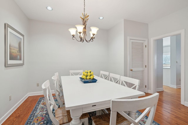 dining area featuring hardwood / wood-style floors and a notable chandelier