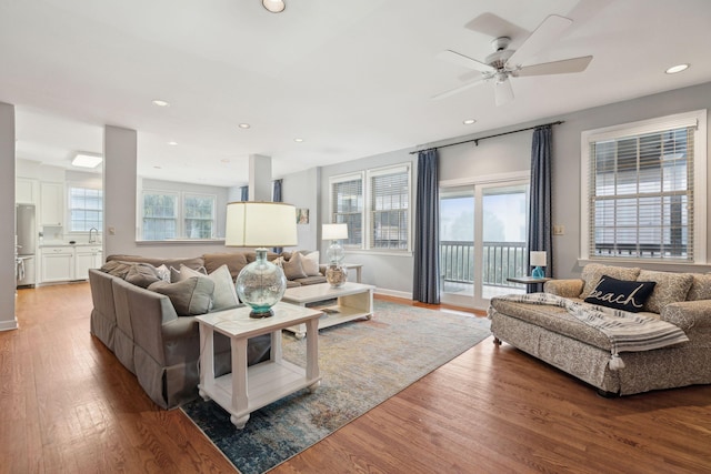 living room featuring sink, wood-type flooring, and ceiling fan