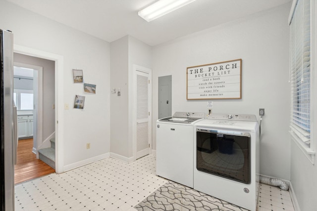 clothes washing area featuring electric panel and washer and dryer