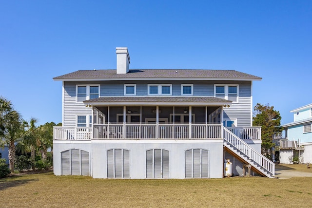 rear view of house with a yard and a sunroom