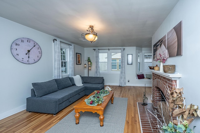 living room featuring a brick fireplace and light hardwood / wood-style flooring