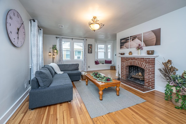 living room with hardwood / wood-style floors and a brick fireplace