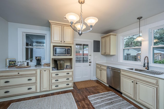 kitchen featuring dark hardwood / wood-style floors, sink, hanging light fixtures, stainless steel appliances, and cream cabinets