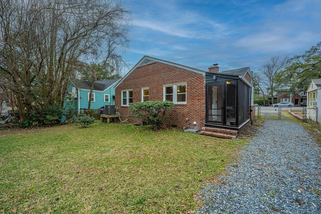 rear view of house featuring a lawn and central air condition unit