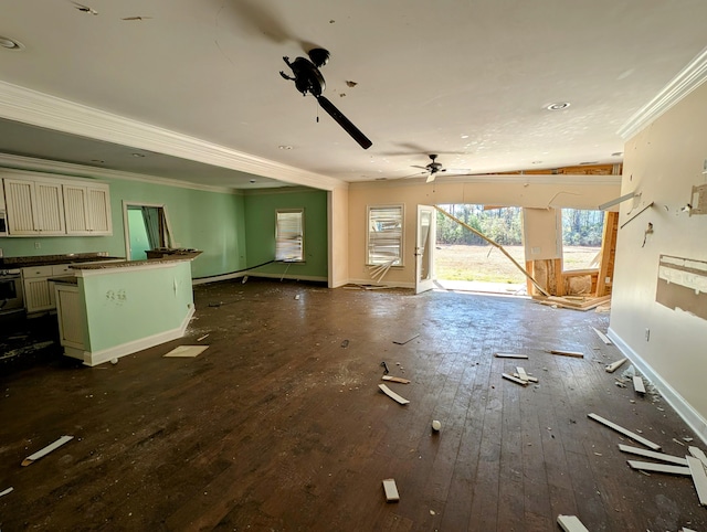 unfurnished living room with baseboards, a ceiling fan, ornamental molding, and dark wood finished floors