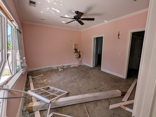 empty room featuring visible vents, a ceiling fan, baseboards, and ornamental molding