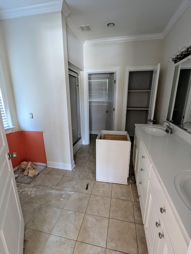 full bathroom featuring double vanity, a sink, tile patterned flooring, a shower stall, and crown molding