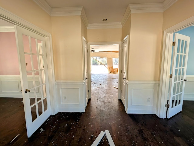 hallway featuring crown molding, dark wood-style floors, french doors, and a wainscoted wall