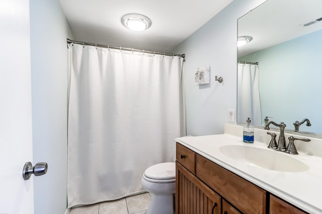 bathroom featuring tile flooring, vanity, and toilet