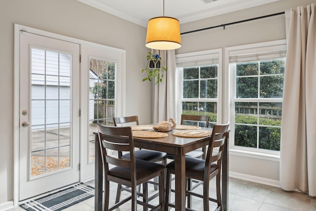 dining room featuring crown molding, light tile patterned floors, and a wealth of natural light