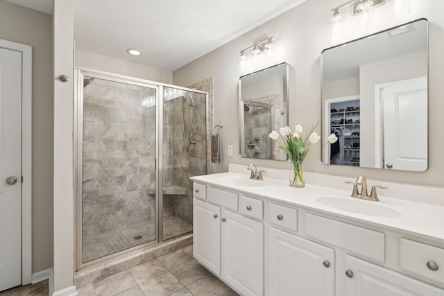 bathroom featuring tile patterned floors, vanity, and a shower with door