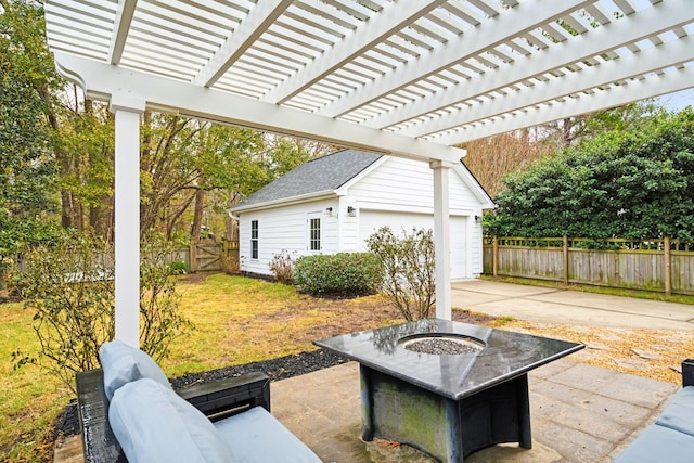 view of patio / terrace featuring a garage, a pergola, an outbuilding, and an outdoor fire pit