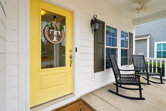 view of exterior entry with ceiling fan and covered porch