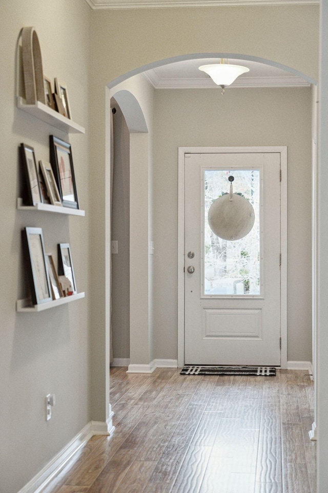 entryway featuring ornamental molding and light hardwood / wood-style floors