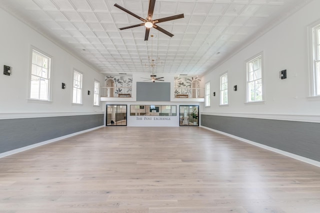 unfurnished living room with wood finished floors, baseboards, an ornate ceiling, and ceiling fan