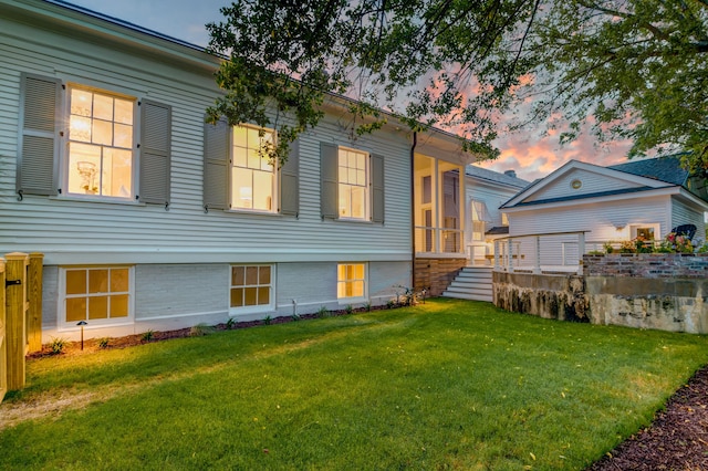 rear view of house featuring a yard