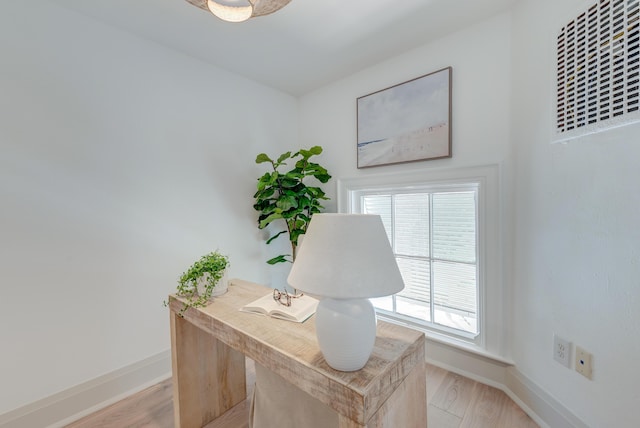 office space with light wood-style flooring, visible vents, and baseboards