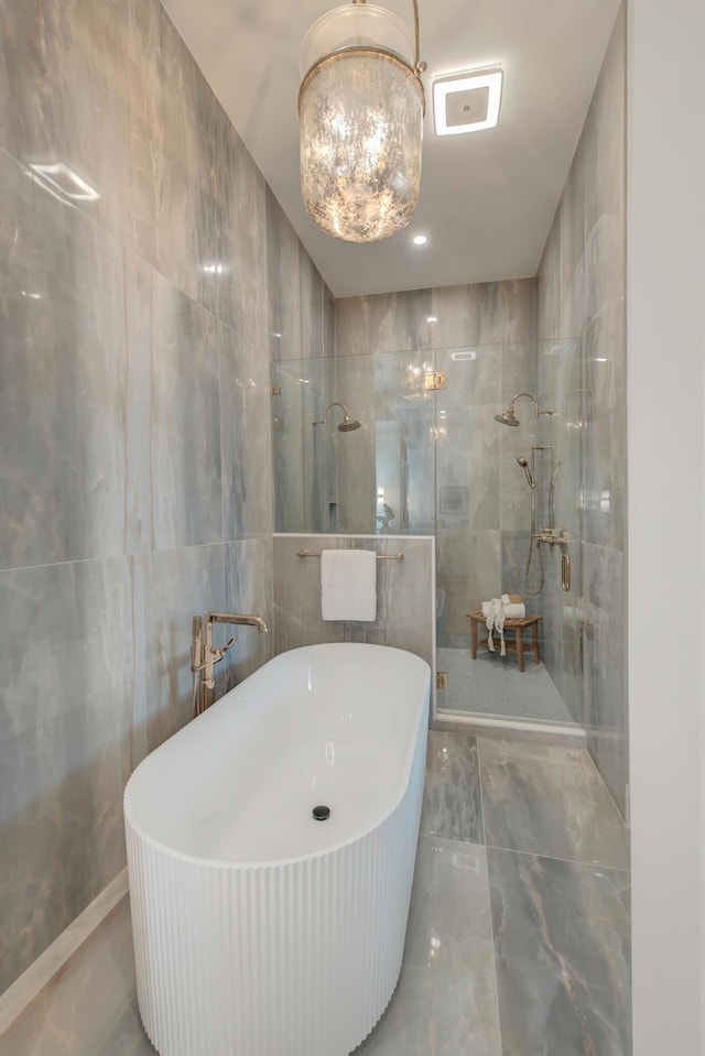 bathroom with a freestanding bath, tile walls, and walk in shower