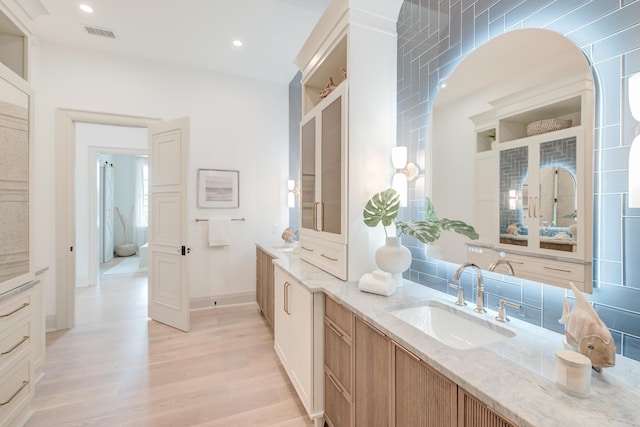 bathroom with recessed lighting, visible vents, wood finished floors, and vanity