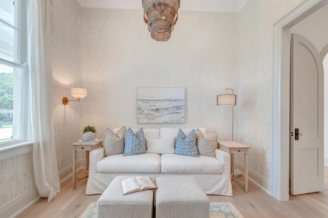 living room with arched walkways, light wood-style flooring, wallpapered walls, and baseboards