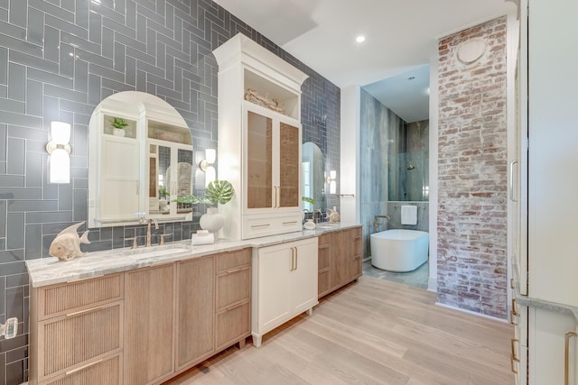 bathroom with tiled shower, a freestanding bath, tile walls, and vanity