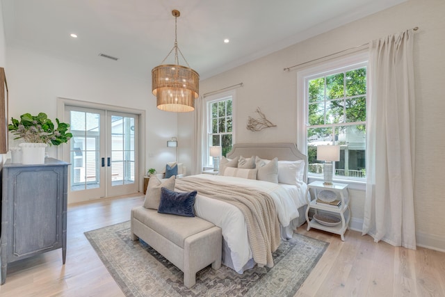 bedroom featuring light wood-type flooring, visible vents, multiple windows, and access to outside