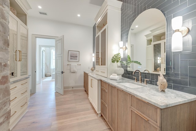 full bath with visible vents, wood finished floors, recessed lighting, baseboards, and vanity