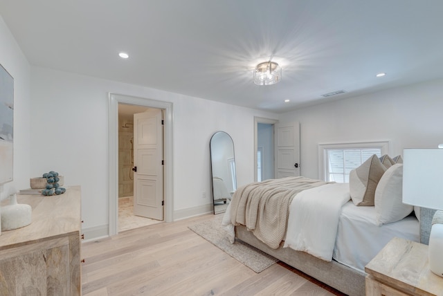 bedroom with visible vents, recessed lighting, arched walkways, light wood-style floors, and baseboards