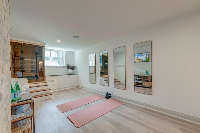 workout room with recessed lighting and light wood-type flooring