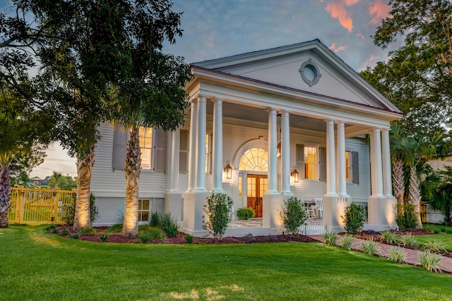 view of front facade featuring a front yard, a porch, and fence