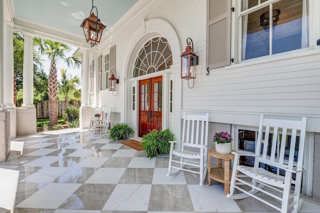 property entrance featuring covered porch and french doors