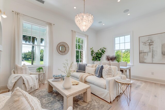 living area with baseboards, light wood finished floors, an inviting chandelier, recessed lighting, and ornamental molding