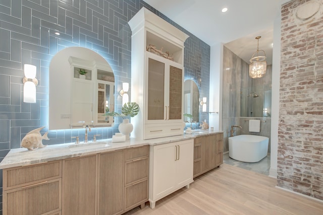 full bathroom with a soaking tub, tile walls, and vanity