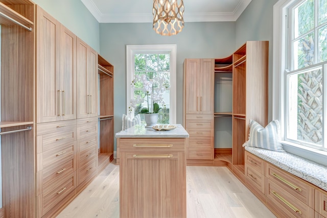 spacious closet featuring light wood-style floors and a chandelier