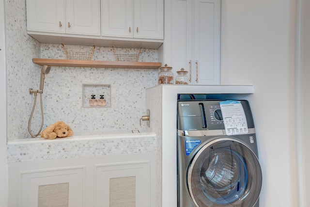 laundry room with cabinet space and washer / dryer