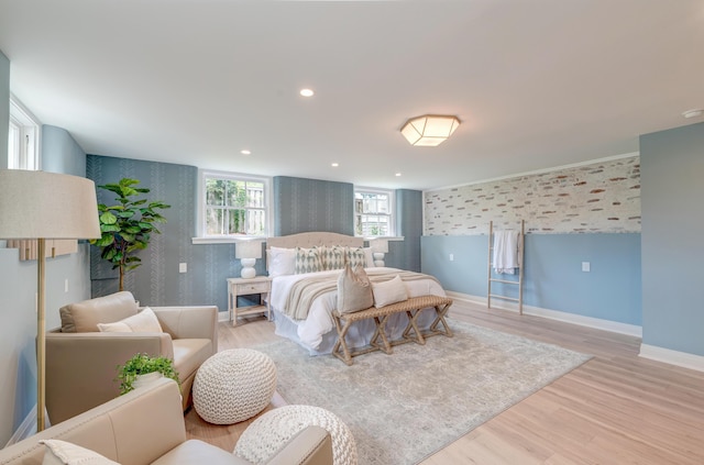 bedroom featuring light wood-type flooring, recessed lighting, wallpapered walls, baseboards, and an accent wall