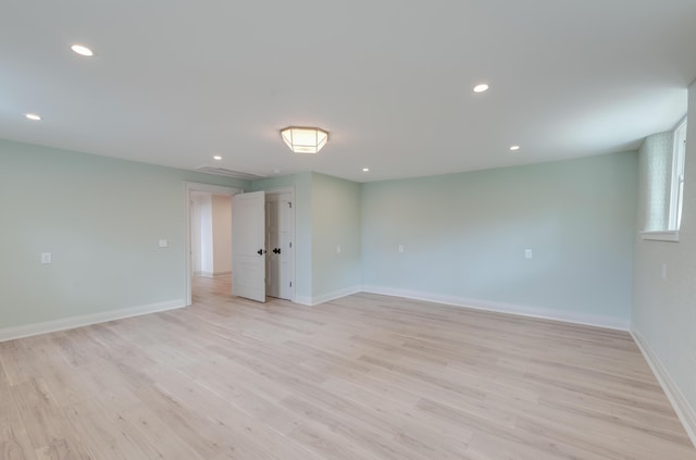 spare room featuring recessed lighting, light wood-type flooring, and baseboards