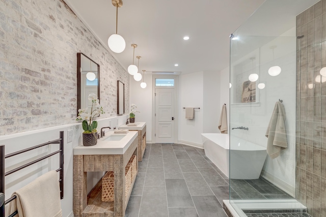 bathroom featuring double vanity, a freestanding tub, a shower stall, and a sink