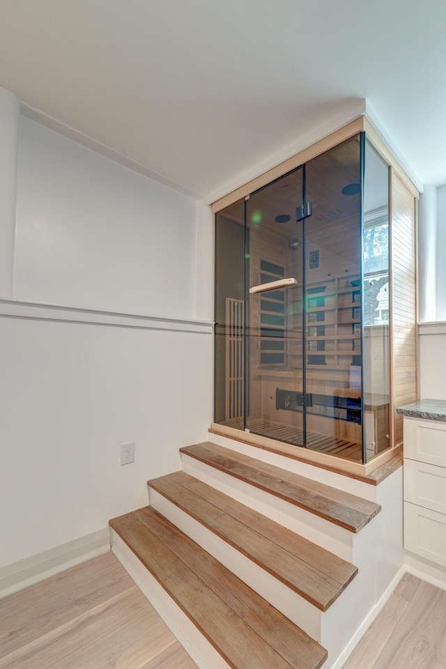 stairway featuring wood finished floors and baseboards