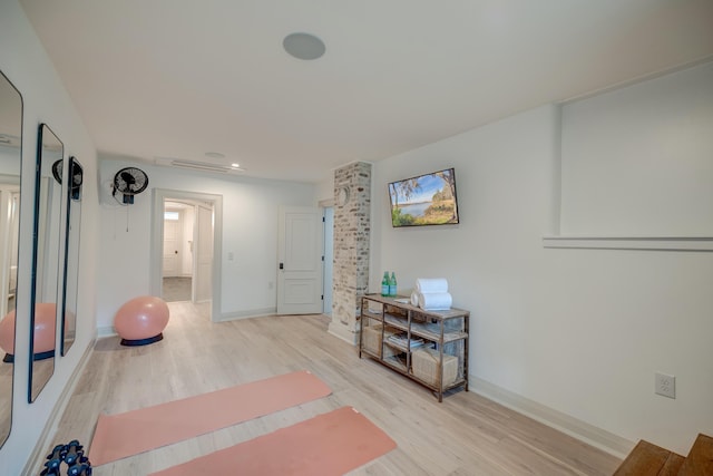 workout room featuring light wood finished floors and baseboards