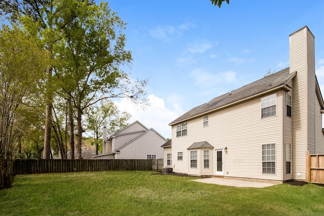 back of property with a lawn, central AC, and a patio area