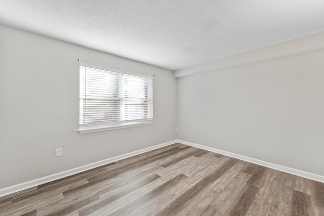 unfurnished room with a textured ceiling and hardwood / wood-style flooring