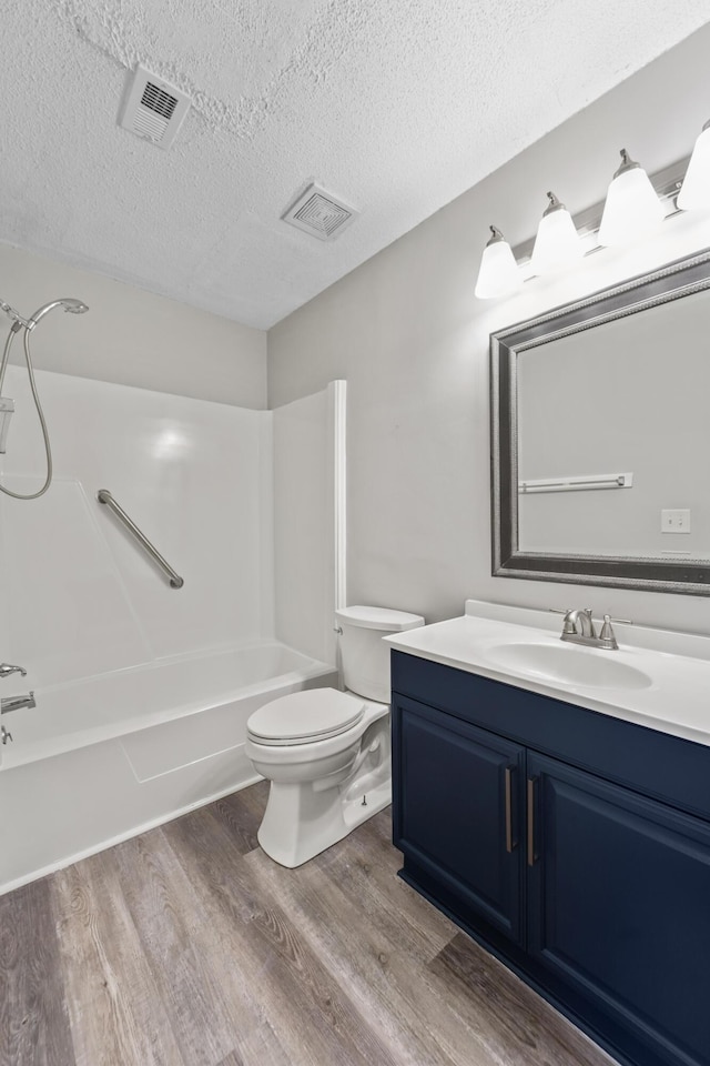 full bathroom featuring toilet, vanity, hardwood / wood-style floors, and tub / shower combination