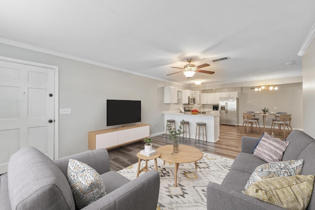 living room featuring ceiling fan, crown molding, and light hardwood / wood-style flooring